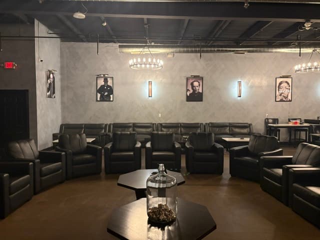 Intimate circle of leather chairs with portraits and iron chandelier
